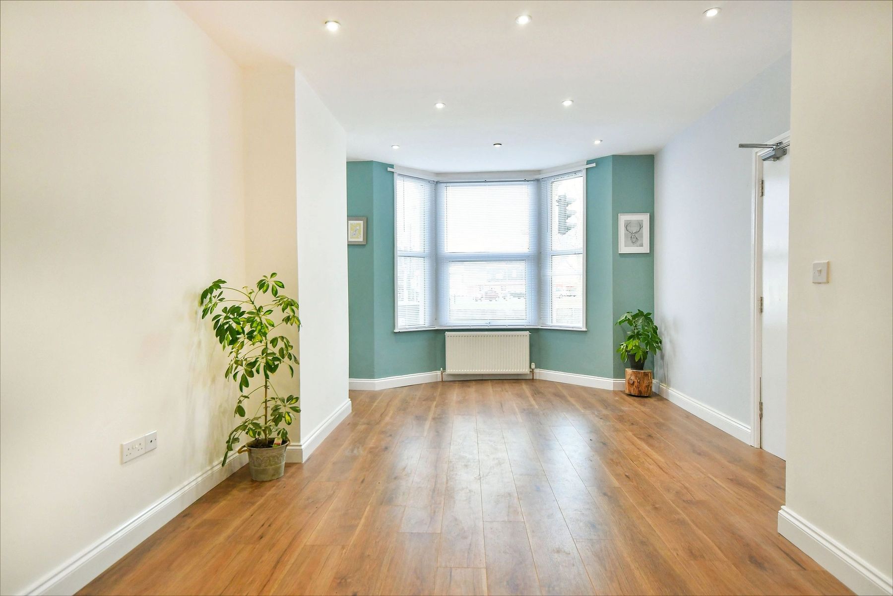 The same room finished: an open plan living space with a teal bay window